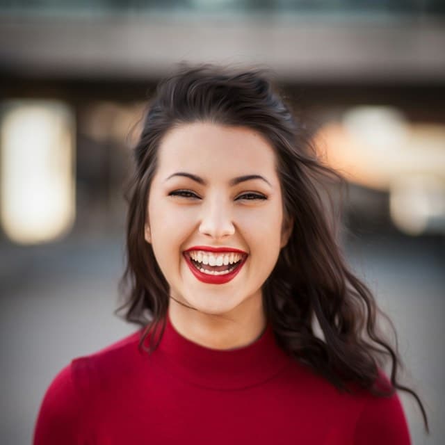 Temporary sample portrait of a smiling woman in a red top; stock model, not a Dillon’s employee.
